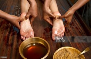 Home indian doctors doing traditional ayurvedic oil foot massage